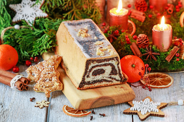 Christmas poppy seed cake and beautiful decorations in the background.