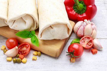 A burrito - mexican dish that consists of a flour tortilla with various ingredients.