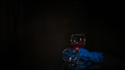 Erotic still life with candles, wine glasses, lingerie in the dark