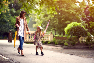 Mother and child holding hands going to school.