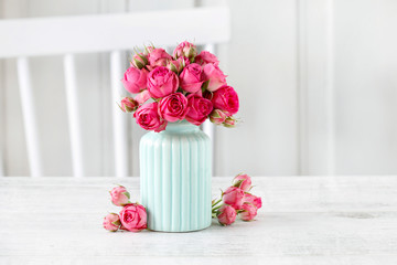 Bouquet of pink roses in blue ceramic vase. Postcard motif.