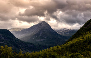 Fototapeta premium Dramatic clouds above myrhyrna mountain in jostedalen valley, norway