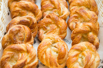 Sweet buns in a basket on a table close-up.