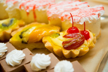 Assorted cakes in a basket on the table close-up.
