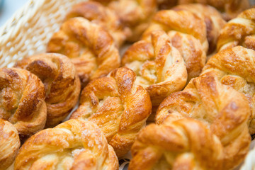 Sweet buns in a basket on a table close-up.