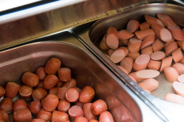 Metal container with sausages in the restaurant's interiors.