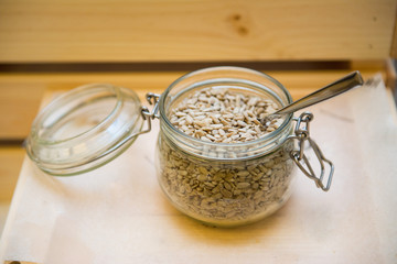 Unshelled sunflower seeds in a glass jar on a table in a restaurant.