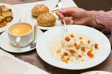 Oatmeal with dried fruits during breakfast.