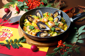 Seafood risotto in a pan on a decorated table. Restaurant dishes.