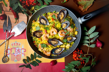 Seafood risotto in a pan on a decorated table top view. Restaurant dishes.