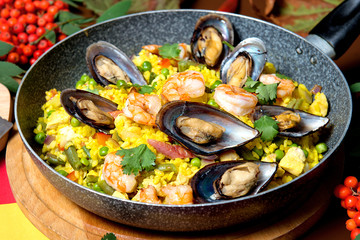 Seafood risotto in a pan on a decorated table. Restaurant dishes.