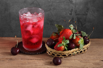 Red cocktail and strawberry and cherry in wooden basket with a blank space for a text, Fruit in kitchen background