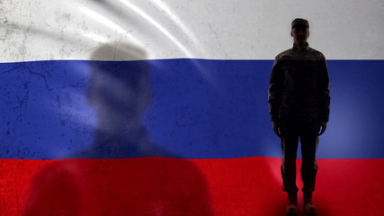 Russian soldier silhouette standing against national flag, proud army sergeant
