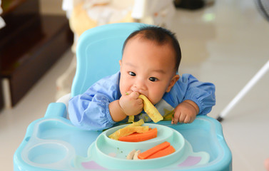 Asian baby boy 6 months old eating with Baby Led Weaning (BLW) method, Self-Feeding