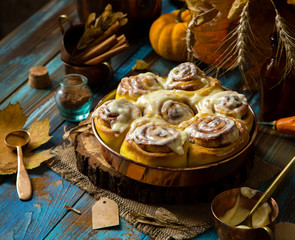 cinnamon rolled pumpkin buns with white sticky glaze on top