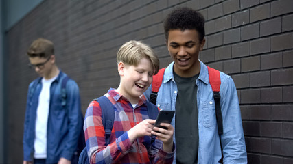 Boys laughing at video about classmate, offensive post in network, cyberbullying