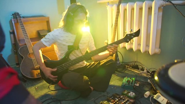 music teacher demonstrates how to use a guitar, recording a new composition