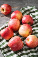 Apples in a basket on a gray wooden background. Autumn harvest