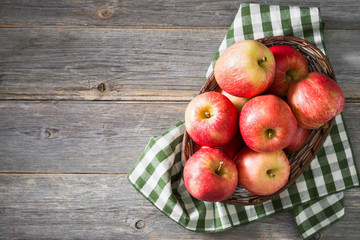 Apples in a basket on a gray wooden background. Autumn harvest