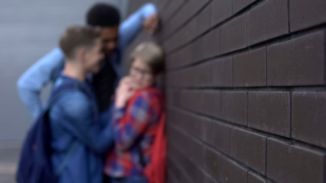 Students bullying classmate in school backyard, children rights blurred template