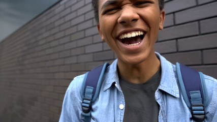 African american teenager mocking into camera, bullying person, victim POV