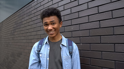 Black boy teasing looking mockingly into camera, emotional bullying in school
