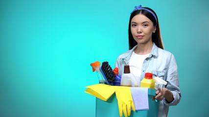 Diligent housewife with basket full of detergent looking at camera, template