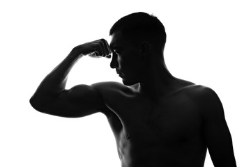 Fototapeta na wymiar silhouette portrait of a muscular man in profile shows a tense bicep on his arm