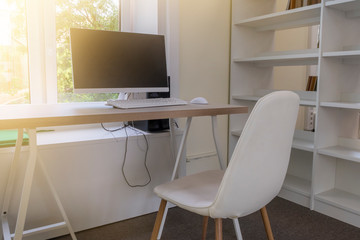 Education background with desk, computer, white chair and bookshelves