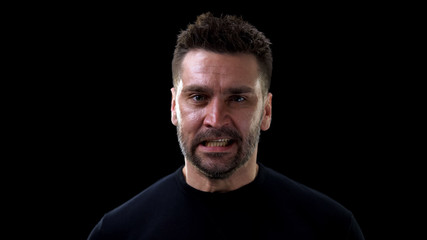 Irritated man black background, negative emotions, problem anger, mental illness
