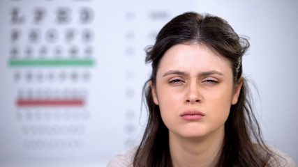 Sleepy overworked female looking to camera, harmful effect on eyesight, burnout