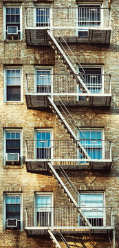Vintage toned picture of an old building with fire escape, New York City, USA.