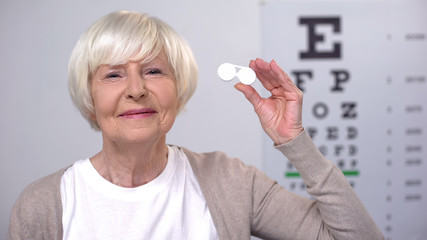 Senior female showing case with contact lenses, preferring modern equipment