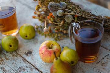 autumn harvest composition with apples pears cup of tea and dry healing herbs