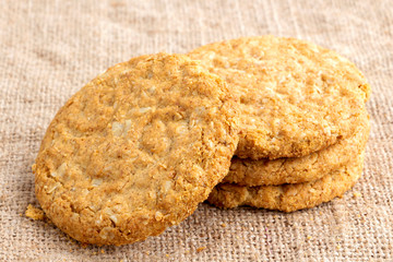 Homemade oat and wholemeal biscuits isolated on brown sackcloth background. Its are a nutrient-rich food associated with protein, fiber and no artificial flavoursor or colour added.