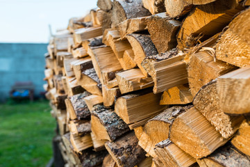 A firewood stacked in a pile, cut trunks. Close up shot, wood background.