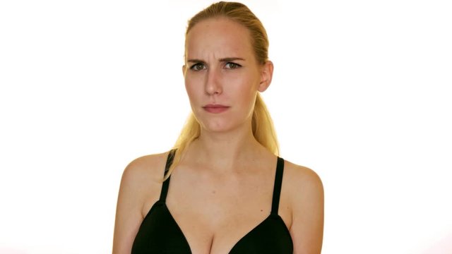 A young blonde woman shrugs and squints, conveying discomfort, uncertainty or disapproval