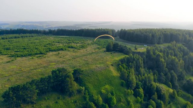 Parasailing held above the green terrain