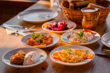 traditional turkish appetizers on table in evening sun light and ayran in a copper glass
