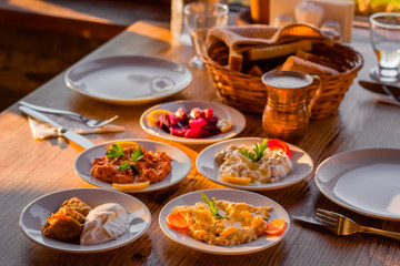 Fototapeta na wymiar traditional turkish appetizers on table in evening sun light and ayran in a copper glass