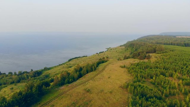 Paraplane is moving above the water and the fields
