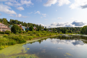 Fototapeta na wymiar The Shokhonka River in Plyos and many small houses in the town