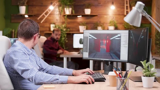 Graphic designer in gaming industry talking detail with his assitant about new video game.