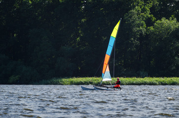 Fototapeta premium HOLIDAY ADVENTURES ON THE YACHT - The catamaran floats on the lake in the sunshine