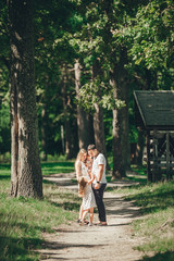 Vertical portrait of a happy young family spending time together on nature, on vacation, outdoors.