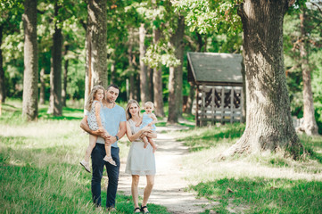 Portrait of a happy young family spending time together on nature, on vacation, outdoors.