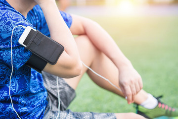 Young sportsman listening to music after morning warm rays of light, lifestyle concept