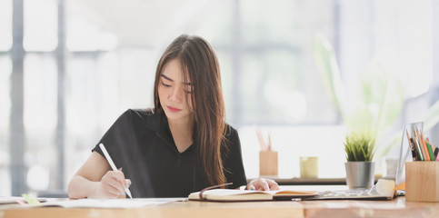 Beautiful young designer editing her concept with tablet