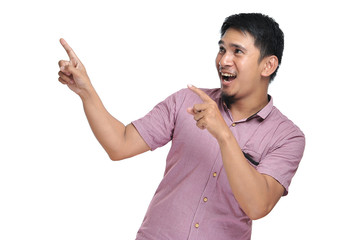 Excited expression of happy smiling asian man pointing of a copyspace