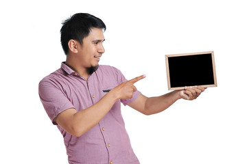 Excited expression of happy smiling asian man pointing the blackboard for copyspace